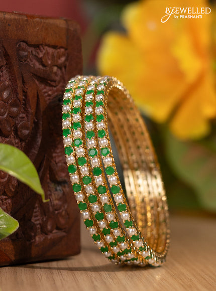 Pearl rajawadi bangles with emerald stones and pearls in gold finish