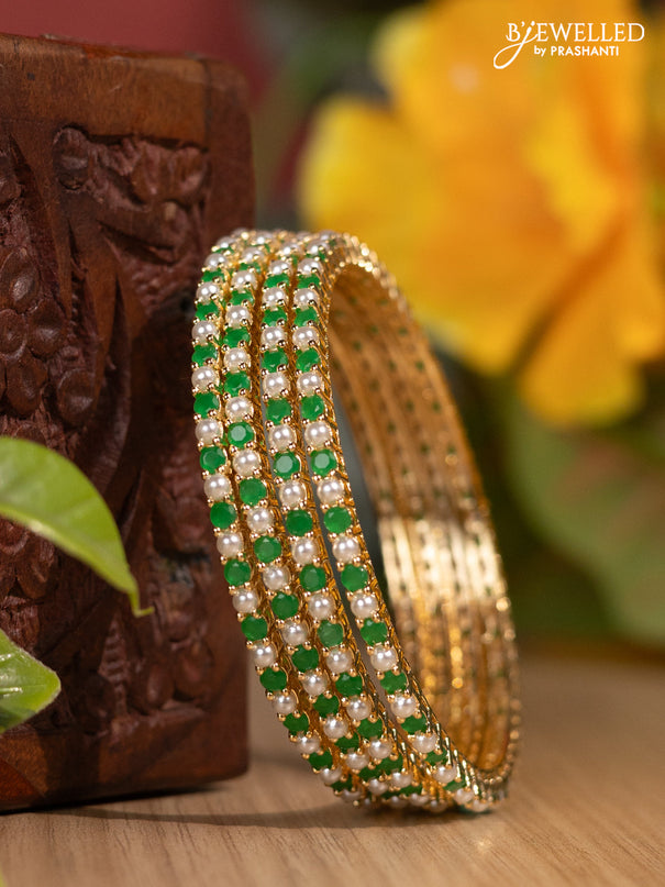 Pearl bangles with emerald stones and pearls in gold finish