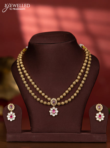 Antique two layer golden beads type necklace with floral pendant in kundan stones