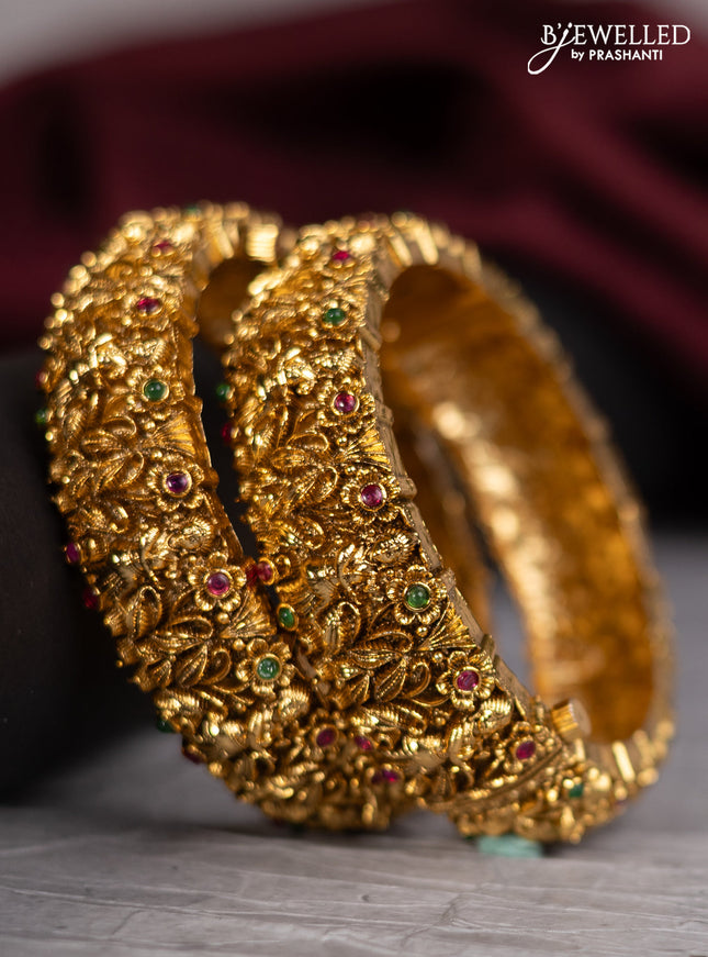 Antique screw type bangles with lakshmi design and kemp stones