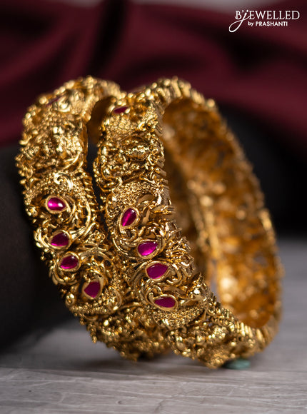 Jadau screw type bangles with lakshmi design and pink jadau stones