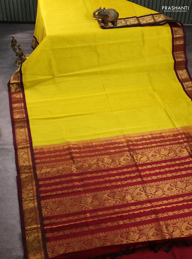 Silk cotton saree yellow and deep maroon with plain body and zari woven korvai border