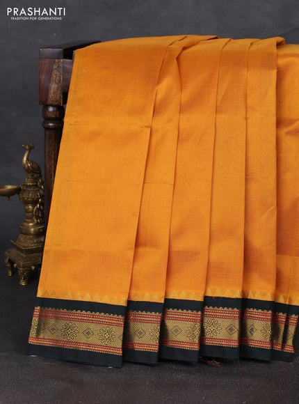 Silk cotton saree dark mustard and bottle green with plain body and zari woven korvai border