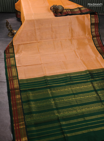 Silk cotton saree pale orange and bottle green with plain body and zari woven korvai border