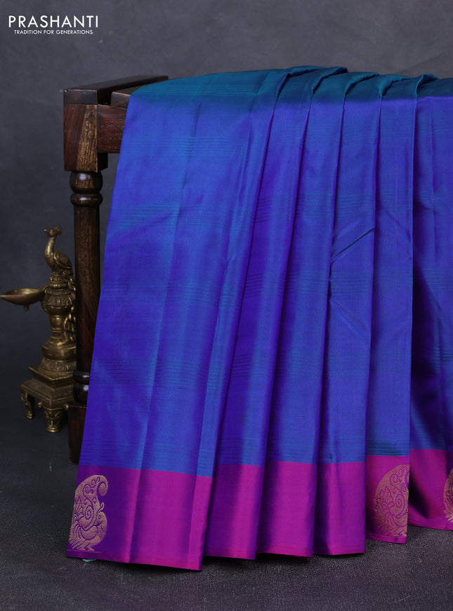 Pure kanchipuram silk saree dual shade of bluish green and purple with plain body and zari woven butta border