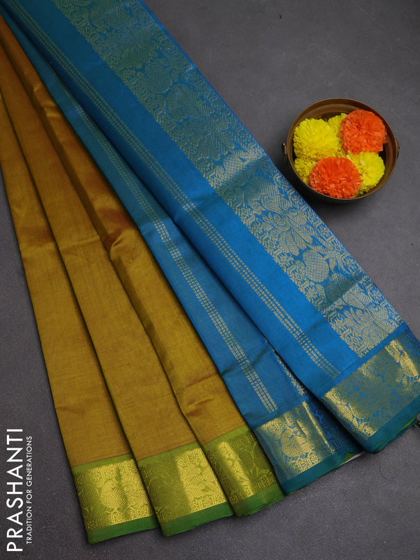 Silk cotton saree dark mustard and dual shade of bluish green with plain body and peacock zari woven border