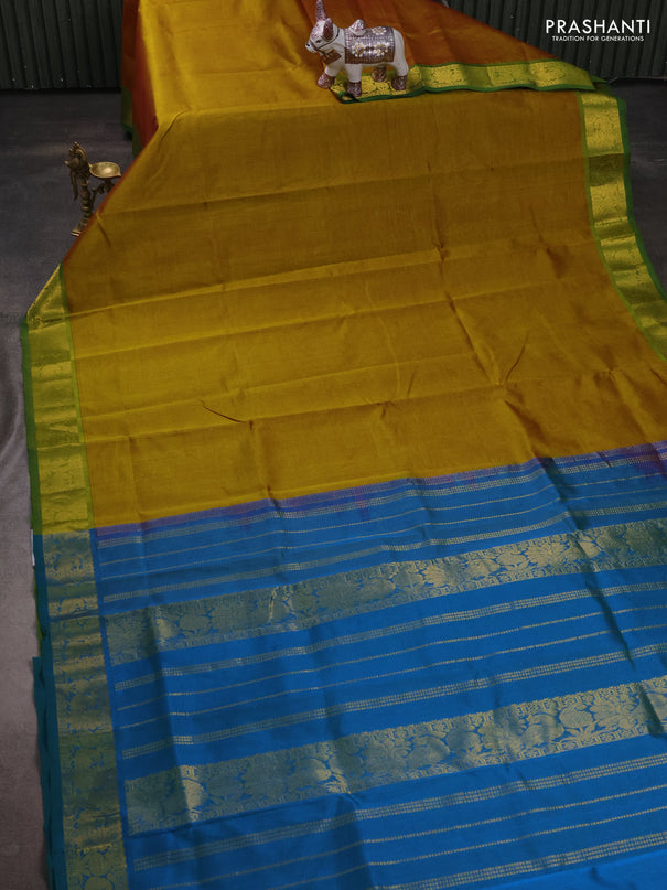 Silk cotton saree dark mustard and dual shade of bluish green with plain body and peacock zari woven border