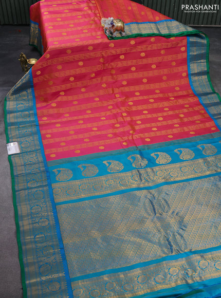 Pure gadwal silk saree dual shade of pinkish orange and dual shade of teal blue with allover zari weaves & buttas and floral zari woven border