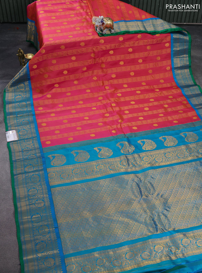 Pure gadwal silk saree dual shade of pinkish orange and dual shade of teal blue with allover zari weaves & buttas and floral zari woven border