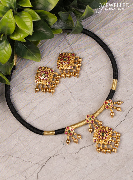 Black thread necklace with kemp stones and golden beads hanging