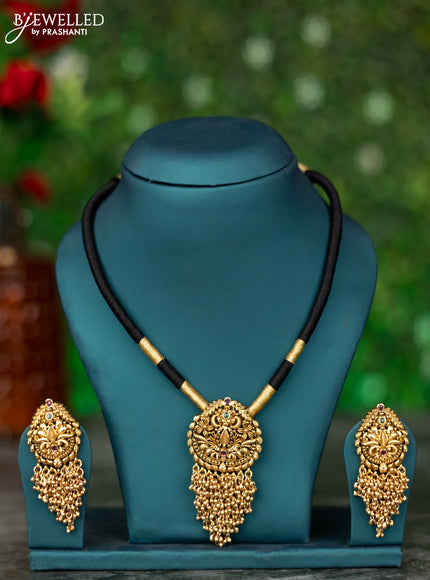 Black thread necklace with kemp stones and golden beads hanging