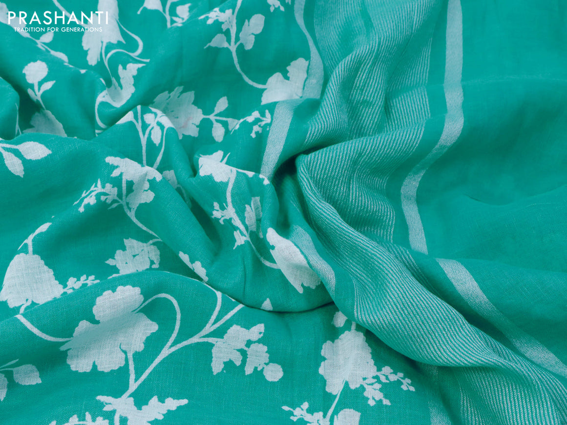 Pure linen saree teal blue with allover floral prints and silver zari woven piping border