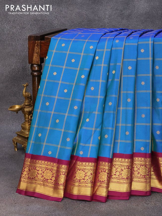 Pure gadwal silk saree dual shade of bluish green and deep purple with allover zari checked pattern & buttas and floral zari woven border