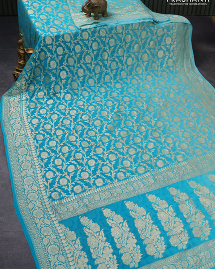 Pure banarasi georgette silk saree teal blue with allover zari woven floral brocade weaves and rich floral zari woven border