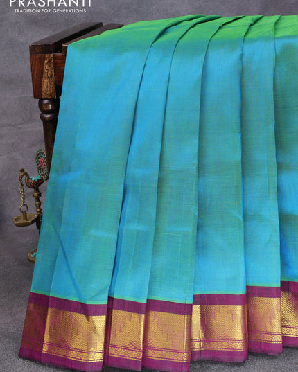 Silk cotton saree dual shade of bluish green and purple with plain body and temple design zari woven korvai border