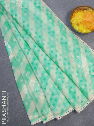 Semi orangza saree off white and teal blue with allover ikat prints & embroidery buttas and crocia lace border